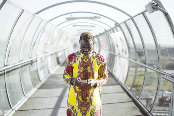 Empresario africano con smartphone y la ropa de típico
 - Foto, imagen