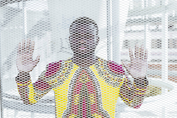 Afrikai férfi mögött egy grillezett kapu - Fotó, kép