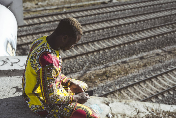 Afrikanischer Geschäftsmann mit Smartphone und typischer Kleidung - Foto, Bild