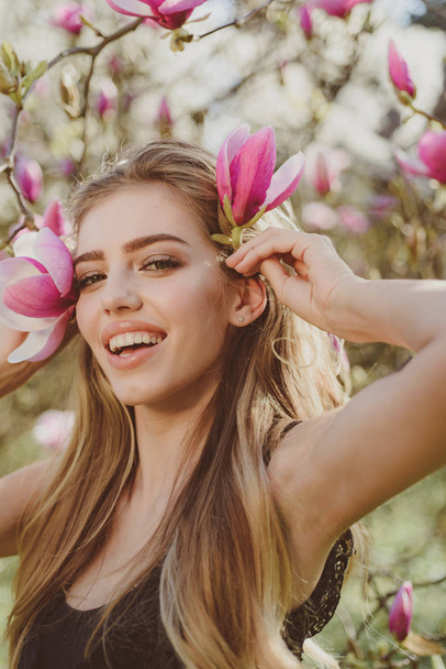 Spring woman with flowers. Happy spring holiday. Blooming. Beautiful girl with pink flowers. Beauty day in spring. Happy sunny blooming spring. - Fotografie, Obrázek
