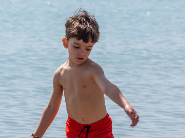 Νεαρό αγόρι που παίζει σε μια παραλία στη Γαλλική Ριβιέρα - Φωτογραφία, εικόνα