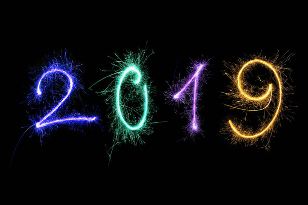 Ευτυχισμένο το νέο έτος 2019 φτιαγμένο από πολύχρωμα πυροτεχνήματα που απομονώνονται σε μαύρο φόντο.  - Φωτογραφία, εικόνα
