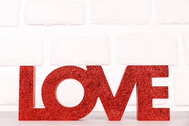 Red sign LOVE. Valentine day concept. Trendy minimalistic holiday design background. Soft focus. Horizontal. Living coral theme - color of the year 2019 - Photo, Image