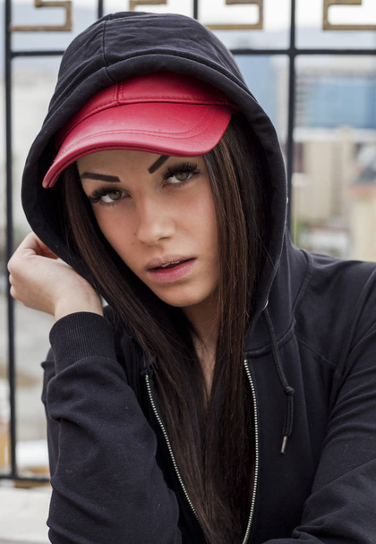 portrait de belle jeune femme posant en bonnet rouge et capuche noire
 - Photo, image