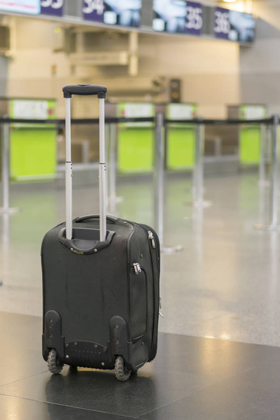 osamělý kufr na letišti. osamělý kufr na letišti. Zapomenutá zavazadla na letišti, prázdné. vertikální Foto. - Fotografie, Obrázek