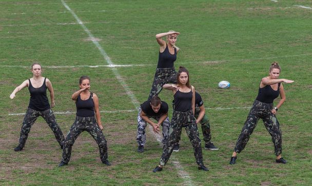 ODESSA, UKRAINE - SEPTEMBER 29, 2018: Speech by beautiful young girls of the fan team during the opening of the rugby championship. Team performance team on the grass field stadium - Фото, изображение