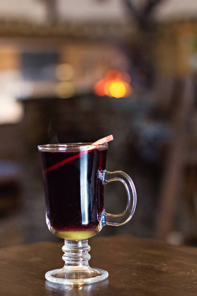 Mulled wine in a beautiful glass. Winter warming drink. Hot mulled wine  on the wooden table.  - Foto, Bild
