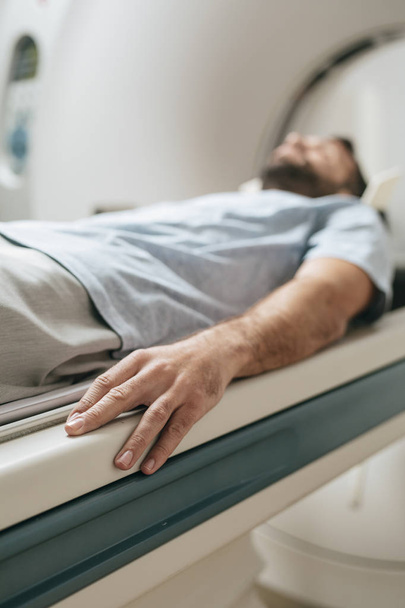 Patient lying on the TC scanner bed waiting to be scanned. - Foto, Bild