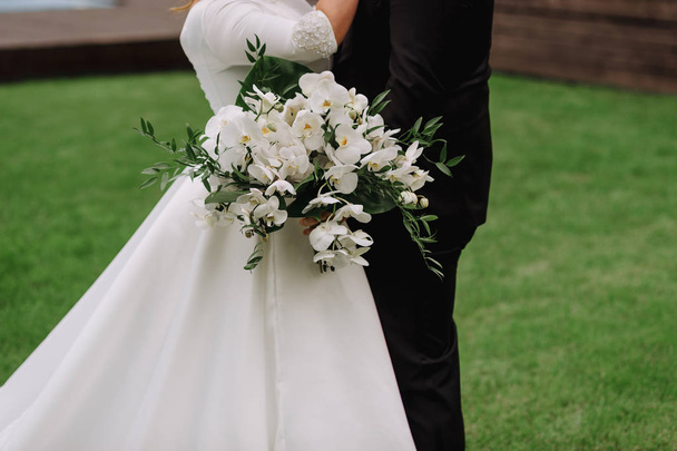 bride holding bouquet of flowers in rustic style, wedding bouquet Groom hugs bride - Photo, Image