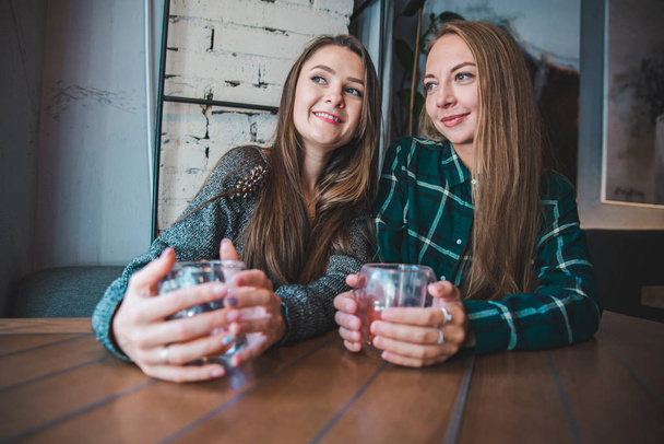 couple girlfriends having fun sitting in cafe drinking fruit tea concept - Foto, afbeelding