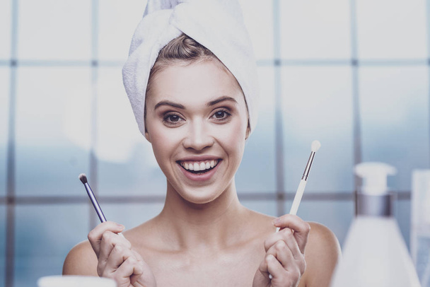 Close up of young woman with makeup brushes - Photo, image