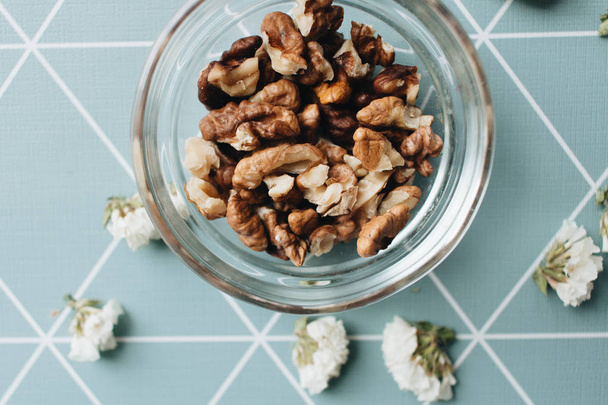 hromadu vyloupané vlašské ořechy ve skleněné míse, zdravé stravovací koncept - Fotografie, Obrázek