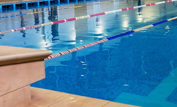 Πισίνα σπορ. Εσωτερικό μπάνιο spotrivnogo πισίνα, διαιρούμενο κολύμπι λωρίδες κυκλοφορίας για τους κολυμβητές, πίνακες για την εκκίνηση κατά τη διάρκεια αγώνων - Φωτογραφία, εικόνα