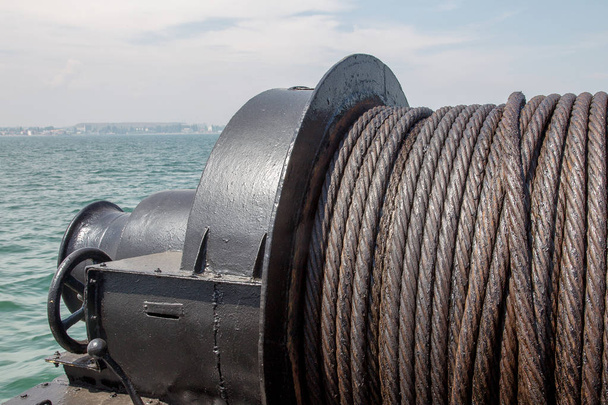 古い金属ケーブル注油海の背景に船舶用ウインチ。海のクローズ アップ潤滑鋼ロープです。Tekstyrny 背景プーリのメタル ケーブルを出荷し、クレーンを採用 - 写真・画像