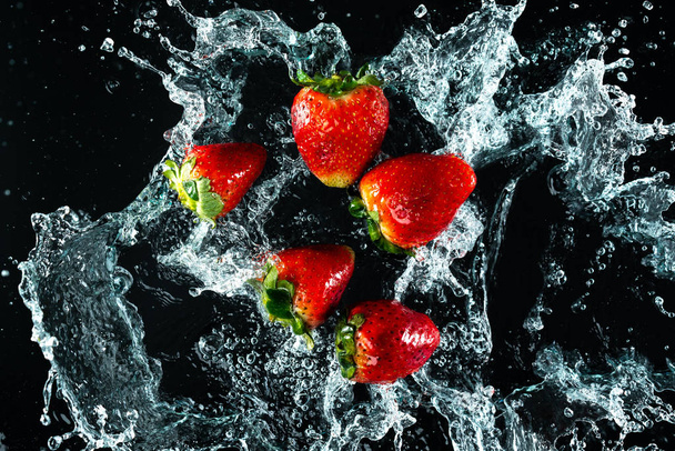 Strawberries Water Splash on black background - Photo, Image