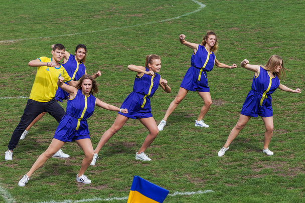 ODESSA, UKRAINE - SEPTEMBER 29, 2018: Speech by beautiful young girls of the fan team during the opening of the rugby championship. Team performance team on the grass field stadium - Foto, immagini