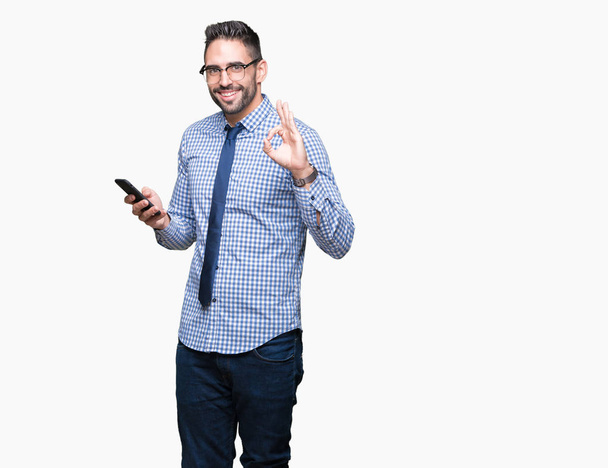 Genç iş adamı Smartphone parmak, mükemmel sembolü ile ok işareti yapıyor izole arka plan üzerinde kullanma - Fotoğraf, Görsel