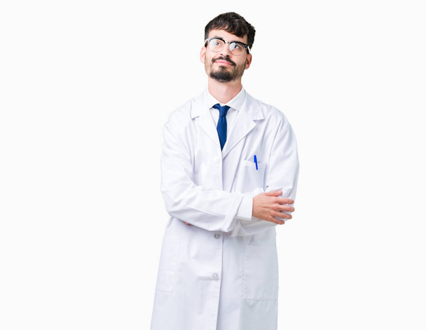 Fiatal szakmai tudós ember visel fehér kabát fölött elszigetelt háttér mosolyogva látszó oldalon, és bámult el gondolkodás. - Fotó, kép