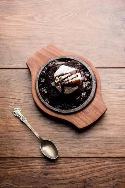 brownie chocolate sizzling é um prato doce feito usando colher de sorvete em cima servido com um derramamento generoso de chocolate derretido. servidor quente. foco seletivo
 - Foto, Imagem