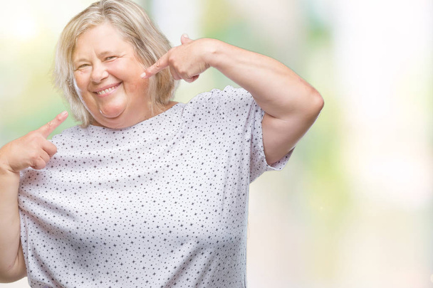 Senior plus size caucasian woman over isolated background smiling confident showing and pointing with fingers teeth and mouth. Health concept. - Photo, Image