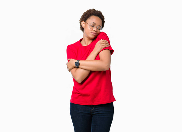 Beautiful young african american woman wearing glasses over isolated background Hugging oneself happy and positive, smiling confident. Self love and self care - Photo, Image