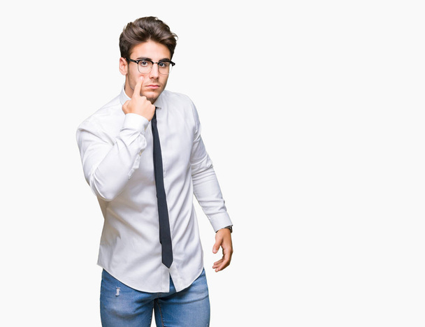Young business man wearing glasses over isolated background Pointing to the eye watching you gesture, suspicious expression - Φωτογραφία, εικόνα