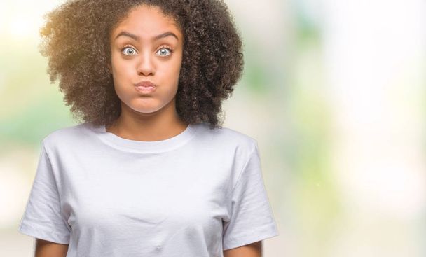 Fiatal afro-amerikai nő át szuszogva pofa, vicces arc elszigetelt háttér. Száj felfújt levegővel, őrült kifejezés. - Fotó, kép