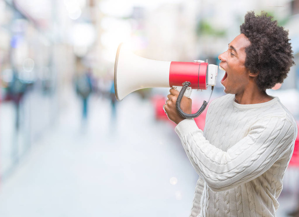 Young handsome afro american black man shouting through megaphone - Photo, Image