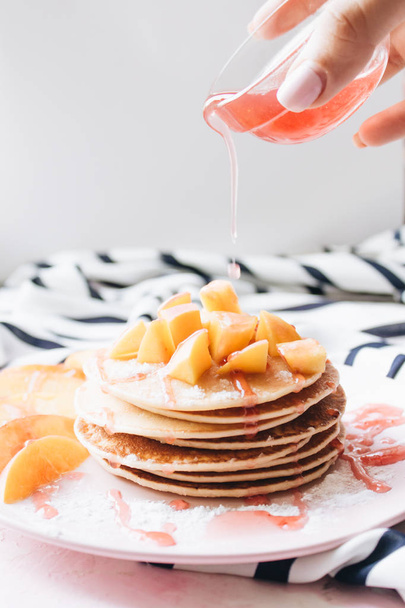 Stapel von leckeren hausgemachten Pfannkuchen mit Sauce und Apfelscheiben  - Foto, Bild