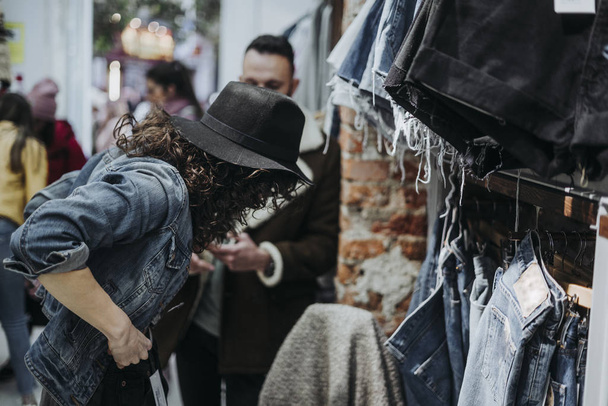 Mujer comprando ropa en la tienda de moda con novio
 - Foto, Imagen