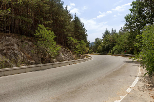 A winding mountain road. Two-way road in the mountains. Paved highway in a mountainous area near the rocky slopes of stone - Φωτογραφία, εικόνα