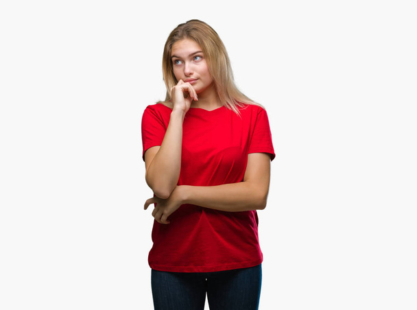 Young caucasian woman over isolated background with hand on chin thinking about question, pensive expression. Smiling with thoughtful face. Doubt concept. - Foto, immagini