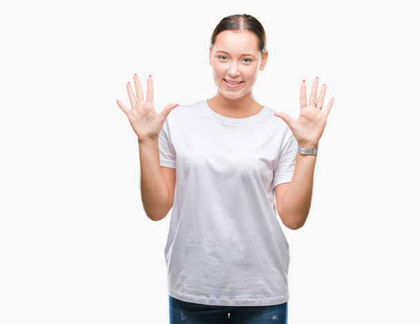 Jonge mooie Kaukasische vrouw over geïsoleerde achtergrond weergeven en met de vingers omhoog nummer tien terwijl lacht zelfverzekerd en blij. - Foto, afbeelding