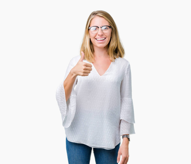 Красива молода жінка в окулярах над ізольованим тлом робить щасливі великі пальці вгору жестом рукою. Затвердження виразу, що дивиться на камеру з успіхом
. - Фото, зображення