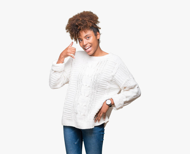 Kaunis nuori afrikkalainen amerikkalainen nainen yllään talvi villapaita yli eristetty tausta hymyillen tekee puhelimen ele käsin ja sormin kuin puhua puhelimessa. Käsitteiden ilmoittaminen
. - Valokuva, kuva