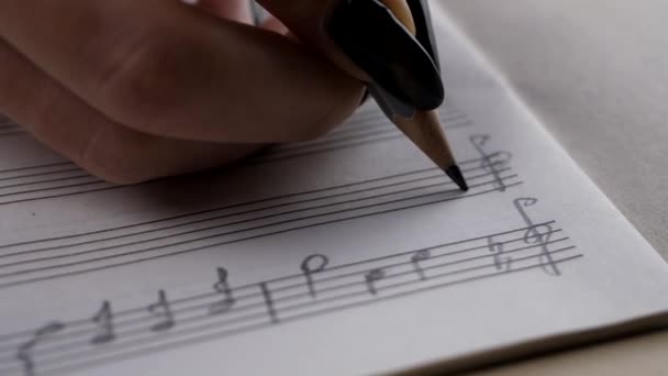 Muzikant of componist hand schrijft een lied of een muzikale werk - Video