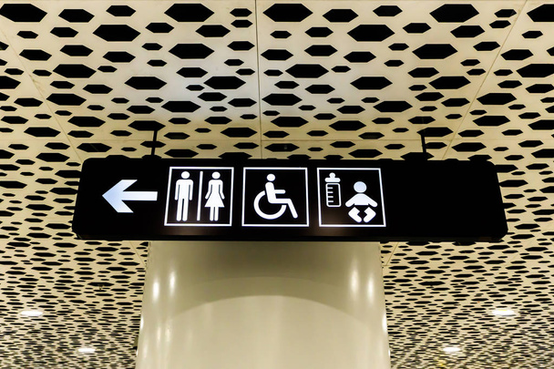 Luchthaven wit gekleurde toilet teken voor gehandicapten en baby's op een zwart bord - Foto, afbeelding