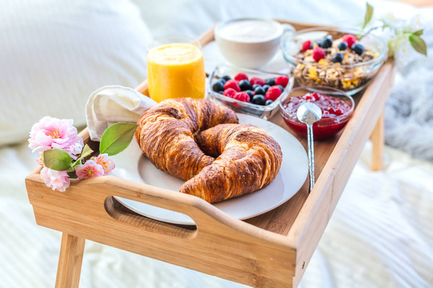 Aamiainen sängyssä hedelmiä ja leivonnaisia tarjottimella
 - Valokuva, kuva