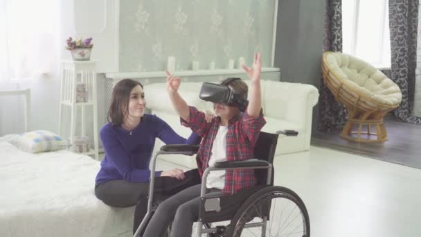 disabled teenager in a wheelchair and her mom at home using vr technology - Πλάνα, βίντεο