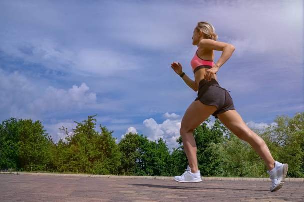 Fit mulher correndo rápido para o esporte no dia ensolarado
 - Foto, Imagem