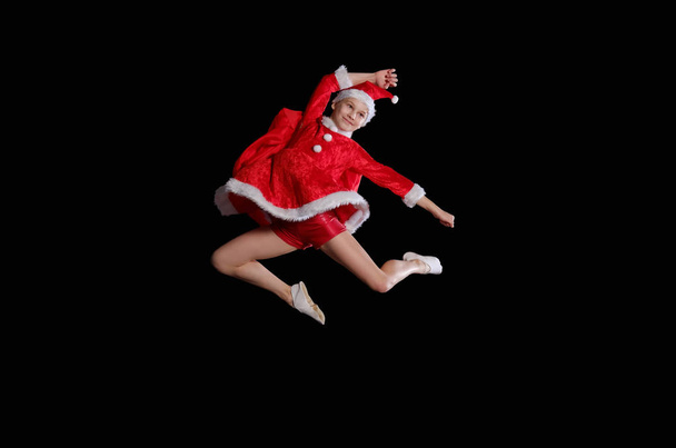Christmas time, childhood, fairy tale. A young girl wearing a Santas costume is flying - Zdjęcie, obraz