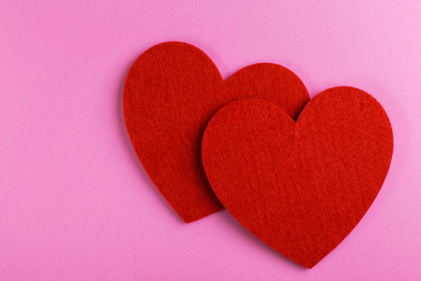 Two red felt heart on bright pink background. St. Valentine's day. Copy space - Zdjęcie, obraz