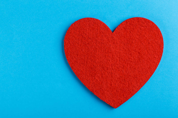 Red felt heart on bright blue background. St. Valentine's day. Copy space - Foto, afbeelding