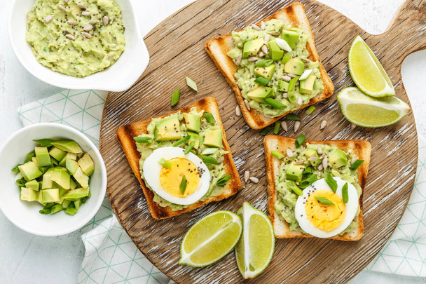 toast all'avocado, sano spuntino di pane grigliato con fette di guacamole avocado, uova sode, semi di chia e cipolle verdi
 - Foto, immagini