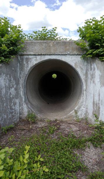 大規模なトンネル セメント パイプ下水嵐水のためのチャネルとして。暗い洞窟、トンネル。都市トンネル。円形トンネル。トンネル セメント パイプが黒い影 - 写真・画像