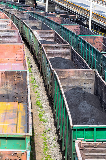 Odessa, Ukraina - Kwiecień 16, 2014: przemysł ciężki - węgiel, rury metalowe, kwadrat żelaza jest transportowany w wagony kolejowe stoczni kolejowego w Odessa, Ukraine Kwiecień 16, 2014. - Zdjęcie, obraz