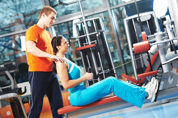 Personal training in gym. fitness instructor exercising woman with training simulator - Foto, Imagen