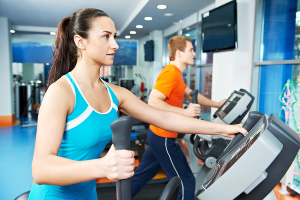 Cardio training. Woman and man at cross-trainers in gym - Photo, Image