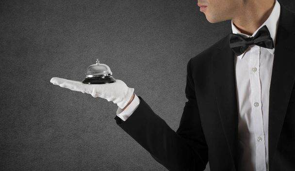 Waiter with bell in hand. Concept of first class service in your business - 写真・画像