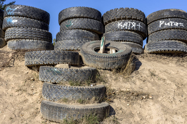 Eliminação de pneus velhos sob a forma de vedação de segurança para os espectadores durante a competição carros perigosos em um carro de pista fechada
 - Foto, Imagem